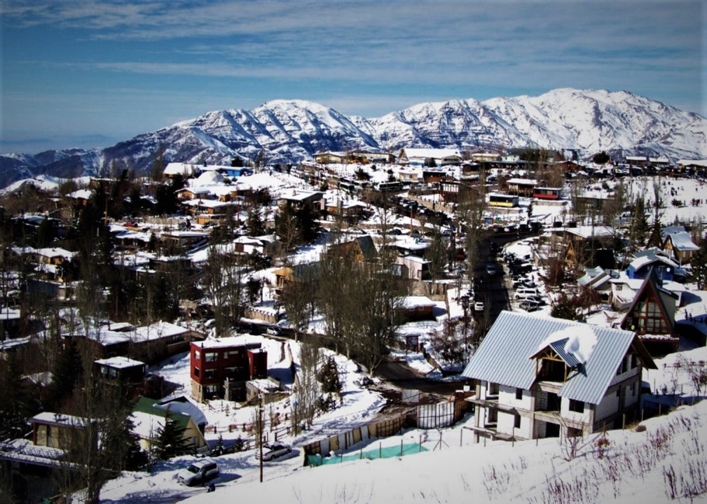 Vista áerea do vilarejo de Farellones, com casas coloridas cobertas de neve