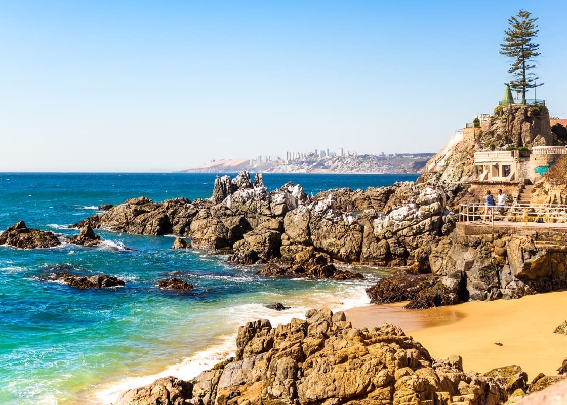 Ondas do oceano pacífico batem em pedras próximo à praia em Valparaiso